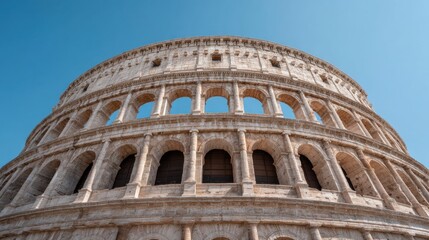 Fototapeta premium Ancient Coliseum Structure Standing Against a Clear Blue Sky with Majestic Arches and Historical Significance in a Stunning Architectural Perspective