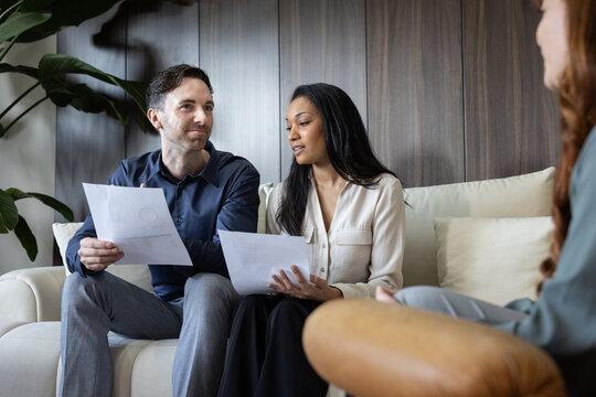 Couple looking at contracts together with an real estate agent