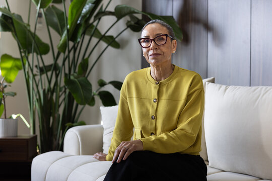 Mature confident businesswoman sitting with Poise on a Sofa