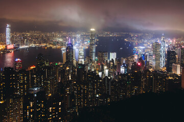 Obraz premium Hong Kong night evening view, China, seen from Victoria Peak observation deck, Lugard road lookout, with Hong Kong downtown skyscrapers and Kowloon island, illuminated city and Victoria Bay at night