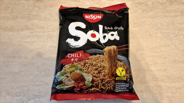 A black package of Nissin Soba Wok Style Chili noodles showing stir-fry noodles with vegetables and a mushroom being lifted by chopsticks. Image taken on April 16, 2026 in Bucharest, Romania.