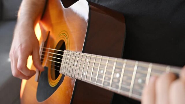 Close Up of Man Strumming Acoustic Guitar