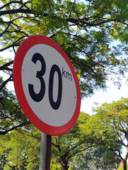 30 km Speed Limit Traffic Sign with Green Tree Background © tujuh17belas