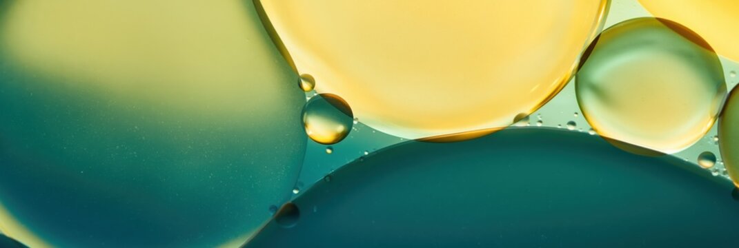 Oil droplets suspended in colored liquid on neutral surface