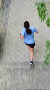 Mujer corredora de running y footing entrenando desde arriba en movimiento y acci&oacute;n haciendo deporte perspectiva cenital