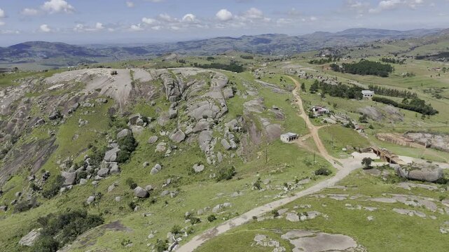 Drone flies backwards high over landscape on a sunny day at Sibebe Rock near Mbabane, Eswatini