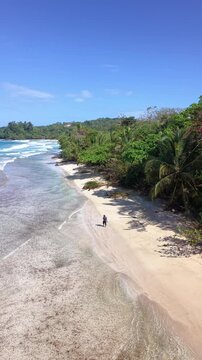 Drone flight along shoreline with waves at Red Frog Beach Panama