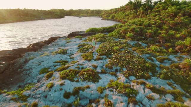 Woman exploring rocky coast and lush tropical lagoon near Akumal Mexico