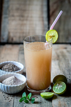 Jal Jeera Indian Summer Drink with Lime Slice Mint and Spices in Glass on Rustic Wooden Background