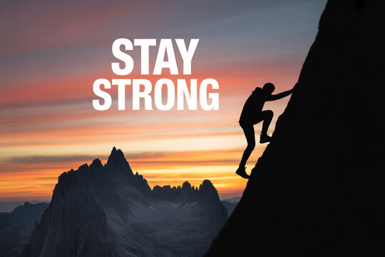 A person climbing a mountain during a vibrant sunset with a motivational phrase