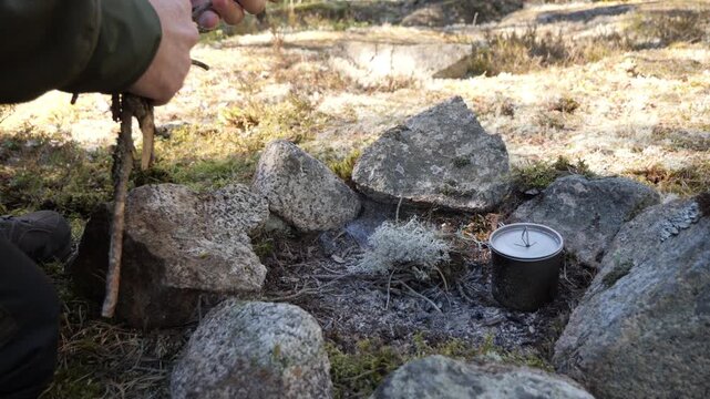Starting campfire with moss tinder in Swedish forest bushcraft