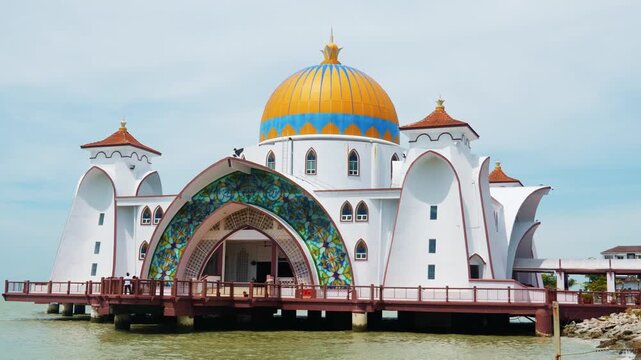 Melaka Straits Mosque standing on stilts over sea, Masjid Selat Melaka, coastal Islamic architecture, blue sky background, travel destination in Malaysia, documentary .
