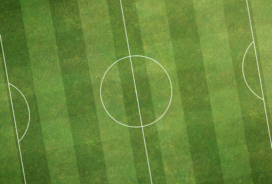 Top View Background of Football Soccer field green have pitch mown grass stripes texture with white line markings according to international standards.