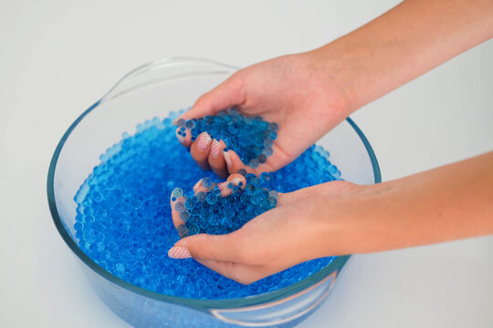 Child play with blue Orbeez balls.