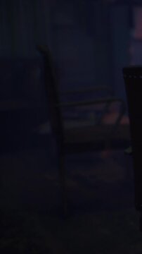 In a darkened room, a solitary chair stands, surrounded by shadows and hints of warmth from distant light. The scene evokes a sense of abandonment and curious exploration.