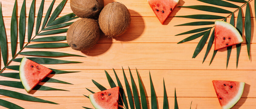 AI generated. Slices of watermelon and coconuts , on a orange background. Summer background.