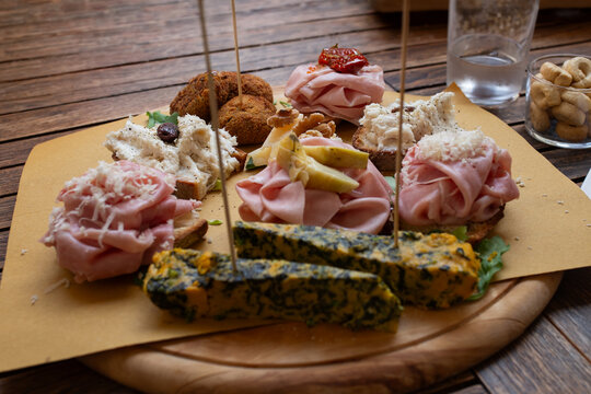 Venetian cicchetti board with crostini mortadella meatballs and frittata on wooden table