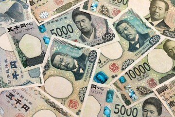 Japanese yen money banknotes pile on table. Japan bills of JPY currency. Concept of economy © Larysa