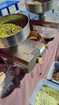 Close-up of a professional screw press extracting organic oil from pumpkin seeds. This footage perfectly demonstrates the traditional healthy food production process.