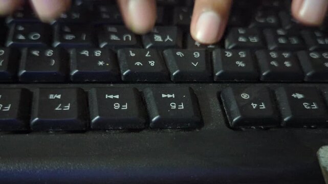 human hands typing on keyboard at night in low light, fingers rapidly pressing keys to input data into computer system, close-up shot of person working on a desktop pc.