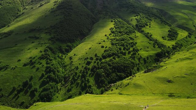 Cinematic 4K ProRes 422 aerial of a lush green mountain valley in Kazbegi. Epic Caucasus mountains landscape at golden hour, Georgia.