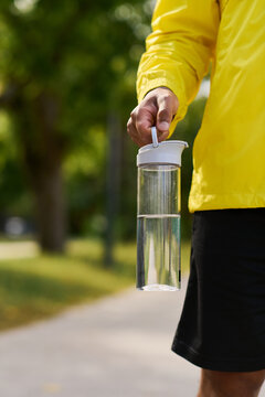 Young man in yellow windbreaker enjoys outdoor workout on a sunny spring day