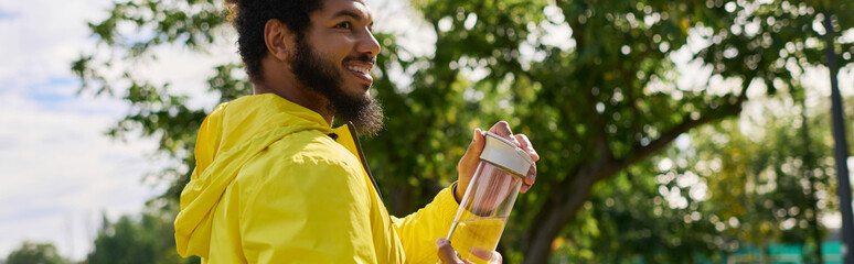 Vibrant yellow windbreaker inspires energy in young man during spring workout outdoors © LIGHTFIELD STUDIOS