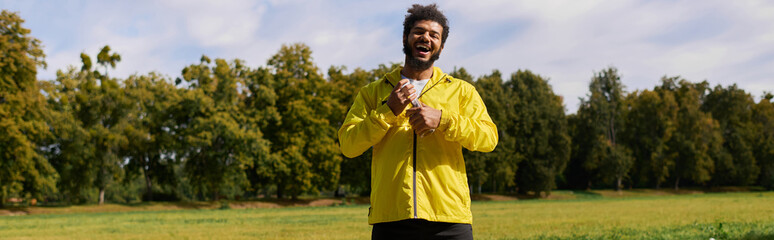 Young man in a yellow windbreaker enjoys a spring workout in the sun © LIGHTFIELD STUDIOS