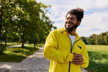 Naklejka premium Young man enjoys a spring workout outdoors in a vibrant yellow windbreaker