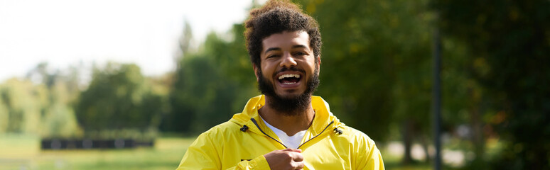 Young man in a bright yellow windbreaker enjoys a sunny outdoor workout © LIGHTFIELD STUDIOS