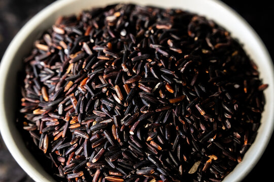 Jasberry, purple rice in a ceramic bowl on a dark surface 