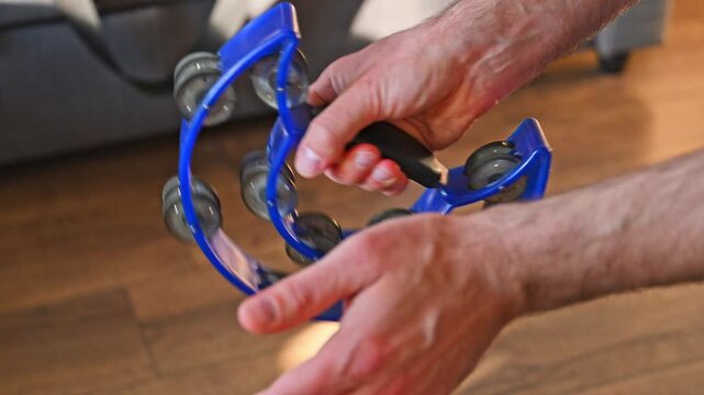 Slow Motion Video of Man Striking Blue Crescent Tambourine Close Up