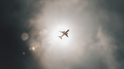 Naklejka premium Airplane flying overhead, creating a silhouette against sun rays breaking through clouds, symbolizing exploration and adventure