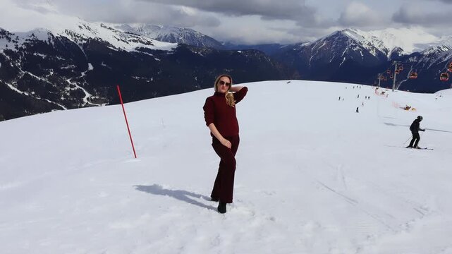 A girl against the backdrop of snowy mountain peaks.