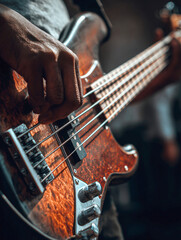 Fototapeta premium Close-Up Action Shot of a Musician Plucking Strings on a Vintage Electric Bass Guitar with a Tortoiseshell Pickguard and Sunburst Finish, Featuring Warm Lighting and Depth of Field in a Music Studio