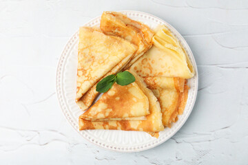 Tasty crepes with mint leaves served on white table, top view © New Africa