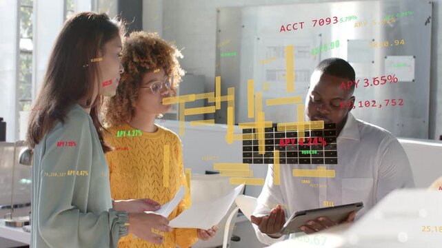 Team in office reviewing tablet papers when candlestick charts appearing driving finance review