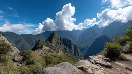 Fototapeta premium A clear view of Machu Picchu from Wayna Picchu shows ancient structures and green vegetation under a blue sky with clouds