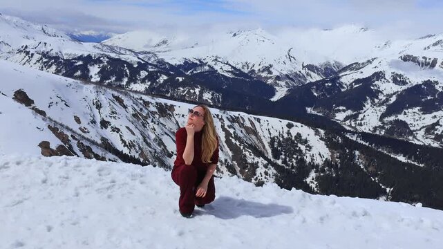A girl against the backdrop of snowy mountain peaks.