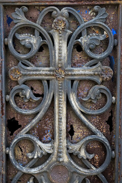 Rusted  gray iron scrollwork cross detail