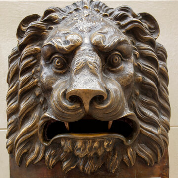 Lion head architectural detail in bronze tones