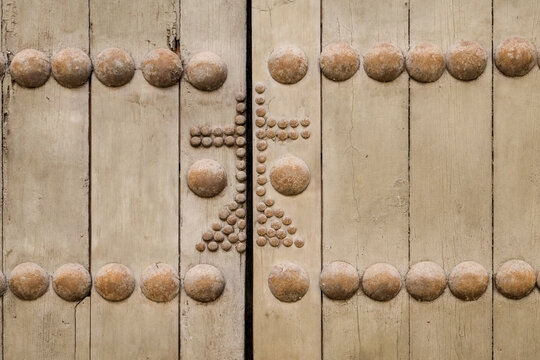 Studded wood door detail with cross motif