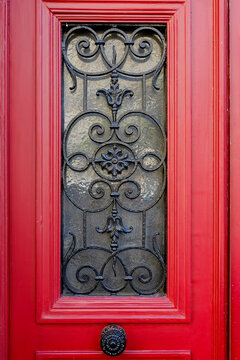 Red door with black wrought iron inset panel