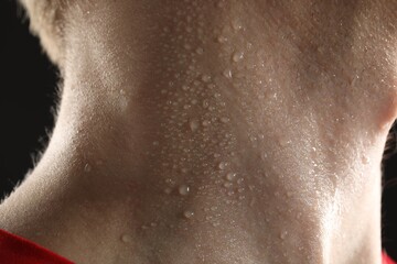 Naklejka premium Man suffering from sweating on black background, closeup