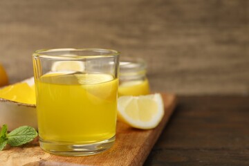 Fototapeta premium Tasty lemon jelly served on wooden table, closeup. Space for text