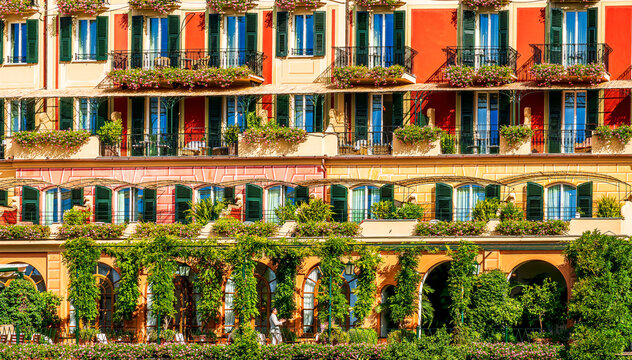 beautiful red and orange hotel facade of house with three green plants and braches and windows in retro italian european style