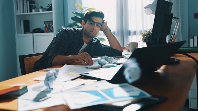 Professional interior designer working on palette and crumpled paper. Top view of skilled business man run out of idea while sleeping at meeting table. Project manager crumpled and throw paper
