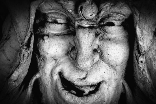 Dark demonic face with sinister smile, concept of envy, jealousy and evil emotions.