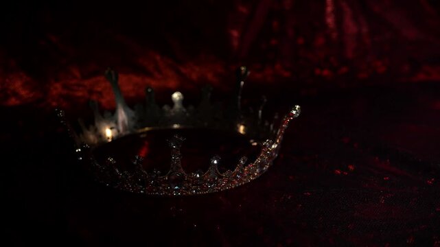 Golden crown on red glitter background with copy space, luxury design backdrop.
Golden crown with sparkling gemstones on a red glitter background with empty copy space. 