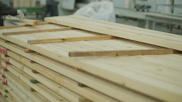A stream of small wooden pieces and offcuts moving along a conveyor belt, representing byproduct management in a large wood factory